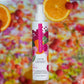 Lustra body oil bottle with a colorful fruit and berry background. lustra body dew sweet temptation sweet temptation pure romance www.VALGINA.com 